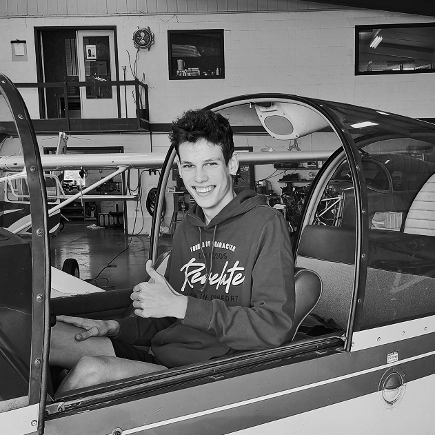 Image en noir et blanc de moi dans le cockpit d'un avion léger, dans un hangar de l'aérodrome de Temploux.